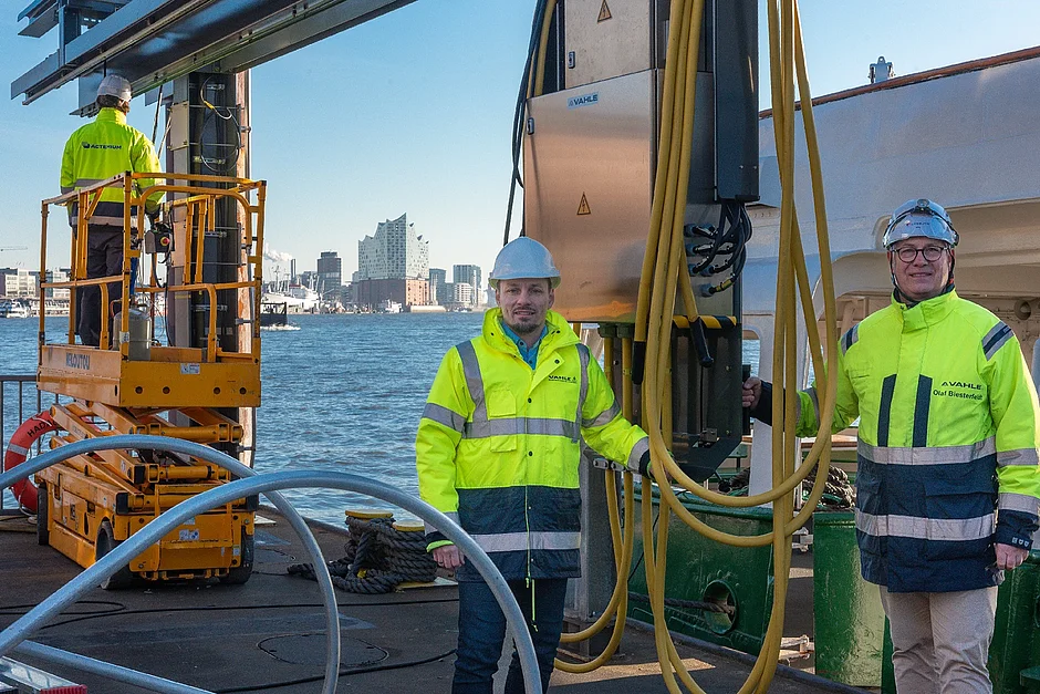 Sergej Nickel und Olaf Biesterfeldt von VAHLE neben dem verfahrbaren Wagen im Hamburger Hafen.